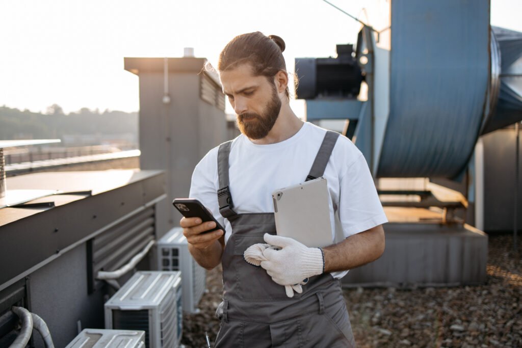 Male master holding tablet and using smartphone on roof